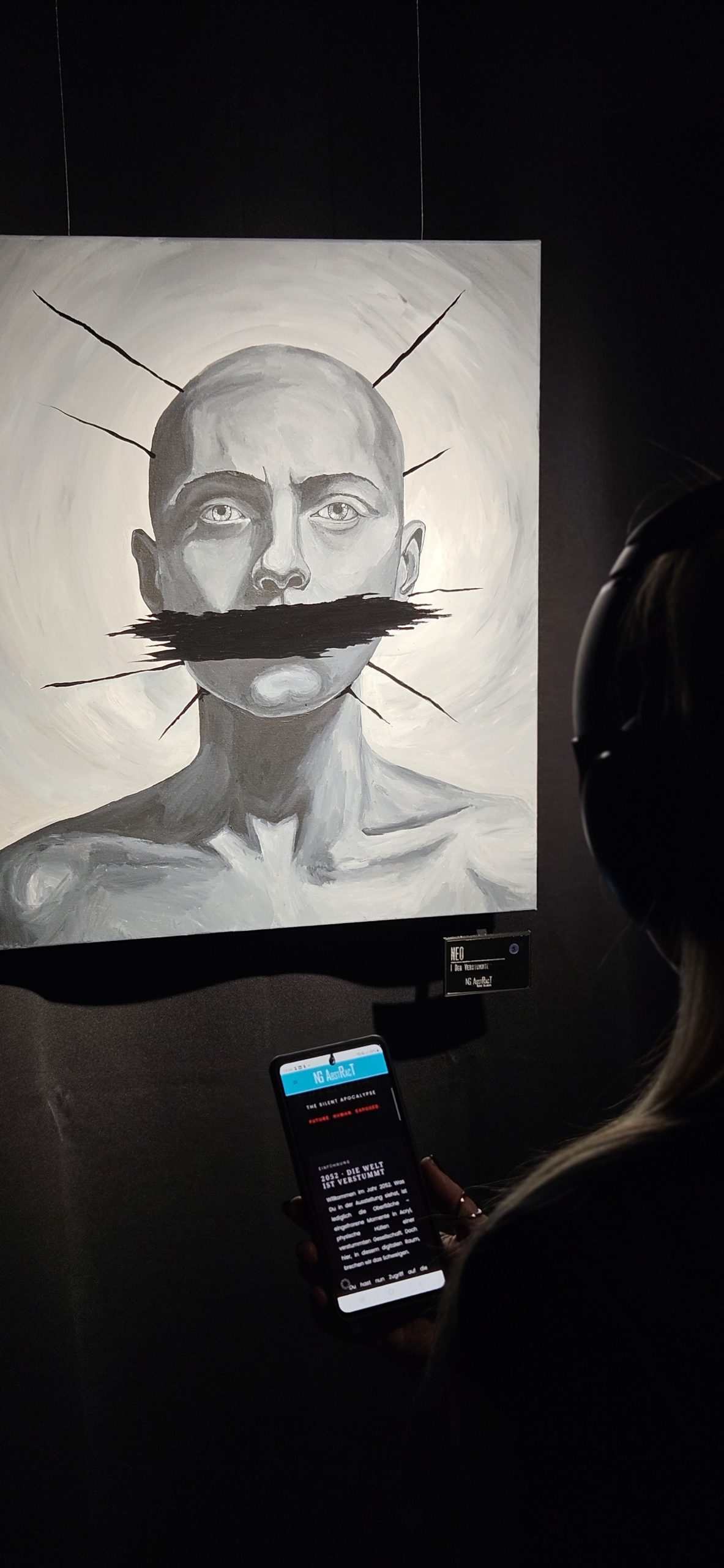 NAdine Gillmaier looks at the painting of one of the soul sirvivors of 2052 and is listening to the audio story.